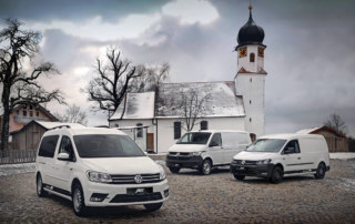 Der ABT e-T6.1 zusammen mit zwei e-Caddys vor einer Kirche