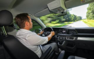 Ein Fahrer demonstriert die ABT e-Caravelle auf einer Landstraße.